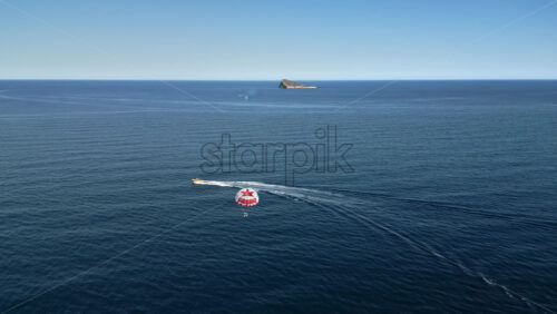 People parasailing on the Mediterranean Sea in Benidorm, Spain - Starpik Stock