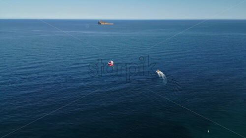 People parasailing on the Mediterranean Sea in Benidorm, Spain - Starpik Stock