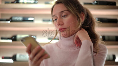 Video - Brunette woman scrolling on her phone at a restaurant