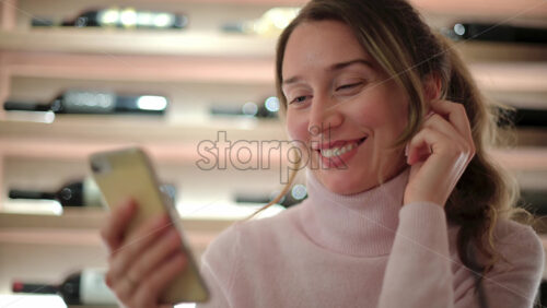 Video - Brunette woman scrolling on her phone at a restaurant