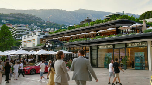 Video - Monaco City, Monaco - October 4, 2024: Luxury cars parked and people moving in front of a Tiffany and Co. store in the city