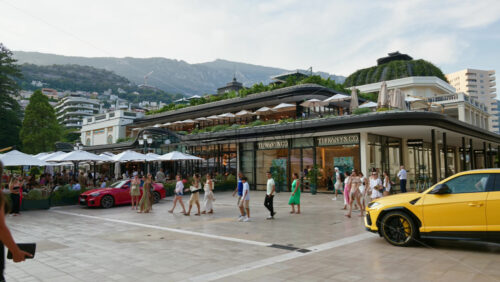 Video - Monaco City, Monaco - October 4, 2024: Luxury cars parked and people moving in front of a Tiffany and Co. store in the city