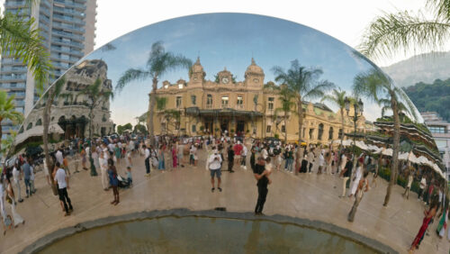 Video - Monte Carlo, Monaco - October 4, 2024: Sky mirror sculpture in front of The Monte Carlo Casino with people walking around it