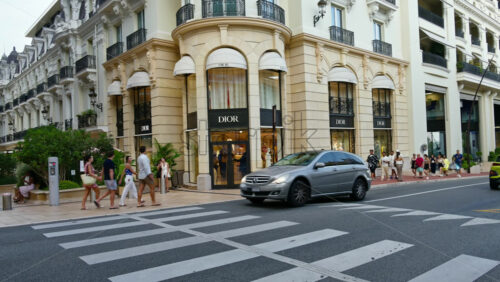 Video - Monte Carlo, Monaco - October 4, 2024: Luxury stores on a street in the city with people and cars moving around