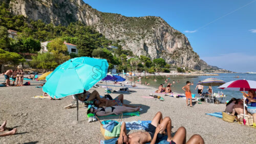 Video - Beaulieu-sur-Mer, France - July 5, 2024: People swimming and relaxing at the Petite Afrique Beach