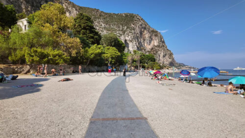 Video - Beaulieu-sur-Mer, France - July 5, 2024: People swimming and relaxing at the Petite Afrique Beach