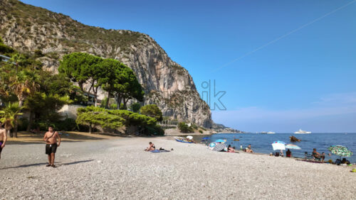 Video - Beaulieu-sur-Mer, France - July 5, 2024: People swimming and relaxing at the Petite Afrique Beach