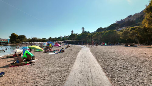 Video - Beaulieu-sur-Mer, France - July 5, 2024: People swimming and relaxing at the Petite Afrique Beach