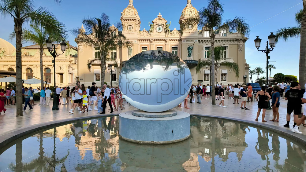 Video - Monte Carlo, Monaco - October 4, 2024: Sky mirror sculpture in front of The Monte Carlo Casino with people walking around it