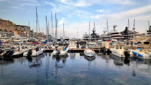 Video - View of white boats docked in the Monaco Marina with the skyline of the city on the background