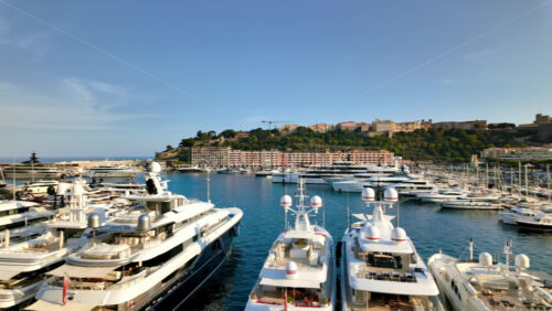 Video - View of white boats docked in the Monaco Marina with the skyline of the city on the background