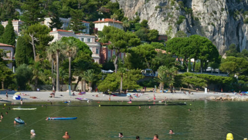 Video - Beaulieu-sur-Mer, France - July 5, 2024: People swimming and relaxing at the Petite Afrique Beach