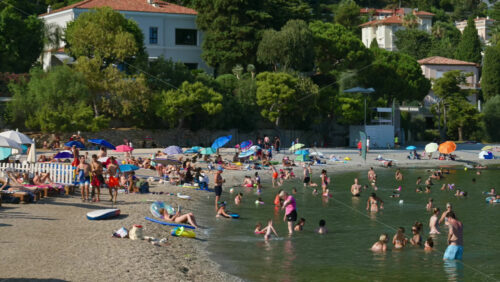 Video - Beaulieu-sur-Mer, France - July 5, 2024: People swimming and relaxing at the Petite Afrique Beach