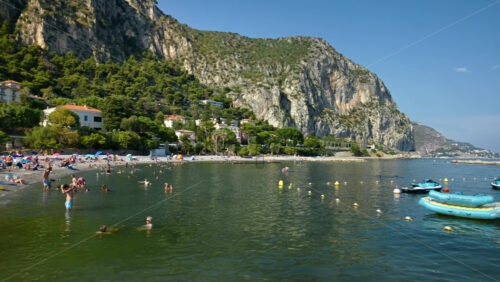 Video - Beaulieu-sur-Mer, France - July 5, 2024: People swimming and relaxing at the Petite Afrique Beach