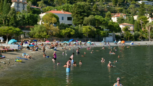 Video - Beaulieu-sur-Mer, France - July 5, 2024: People swimming and relaxing at the Petite Afrique Beach