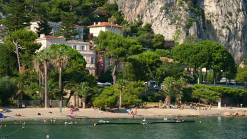 Video - Beaulieu-sur-Mer, France - July 5, 2024: People swimming and relaxing at the Petite Afrique Beach