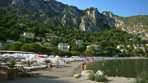 Video - Beaulieu-sur-Mer, France - July 5, 2024: People swimming and relaxing at the Petite Afrique Beach