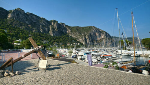 Video - Beaulieu-sur-Mer, France - July 5, 2024: Boats docked in the port with the mountains on the background