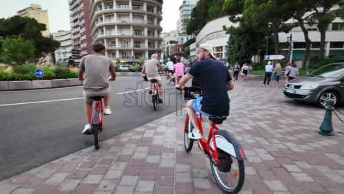 Video - Monaco city, Monaco - September 14, 2024: People biking on the streets of the city in daylight
