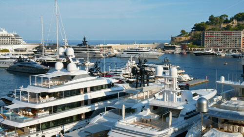 Video - View of white boats docked in the Monaco Marina with the skyline of the city on the background
