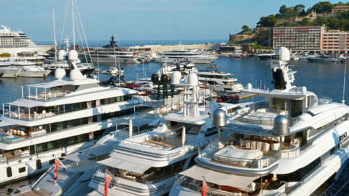 Video - View of white boats docked in the Monaco Marina with the skyline of the city on the background
