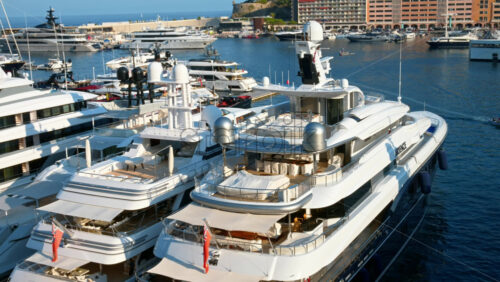 Video - View of white boats docked in the Monaco Marina with the skyline of the city on the background