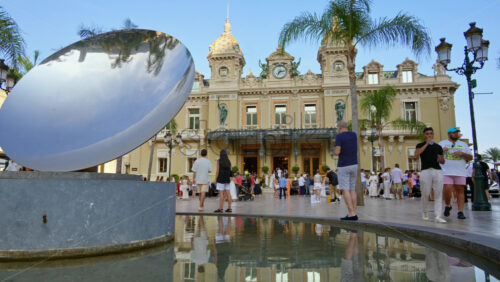 Video - Monte Carlo, Monaco - October 4, 2024: Sky mirror sculpture in front of The Monte Carlo Casino with people walking around it
