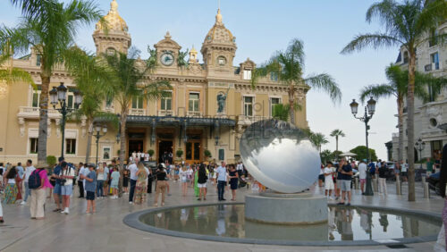 Video - Monte Carlo, Monaco - October 4, 2024: Sky mirror sculpture in front of The Monte Carlo Casino with people walking around it