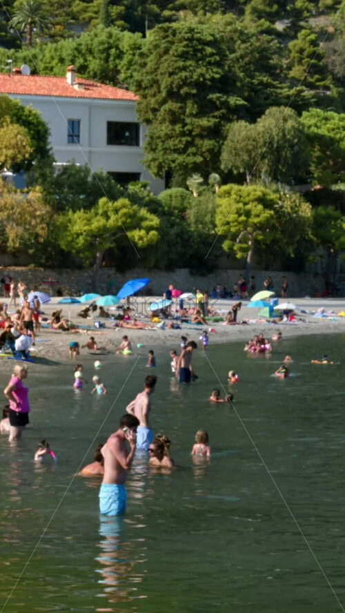 Video - Beaulieu-sur-Mer, France - July 5, 2024: People swimming and relaxing at the Petite Afrique Beach. Vertical