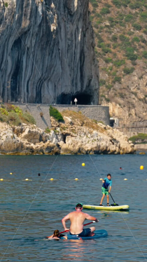 Video - Beaulieu-sur-Mer, France - July 5, 2024: People swimming and relaxing at the Petite Afrique Beach. Vertical