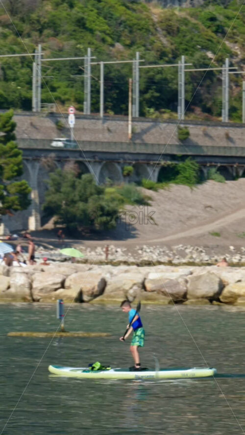 Video - Beaulieu-sur-Mer, France - July 5, 2024: People swimming and relaxing at the Petite Afrique Beach. Vertical