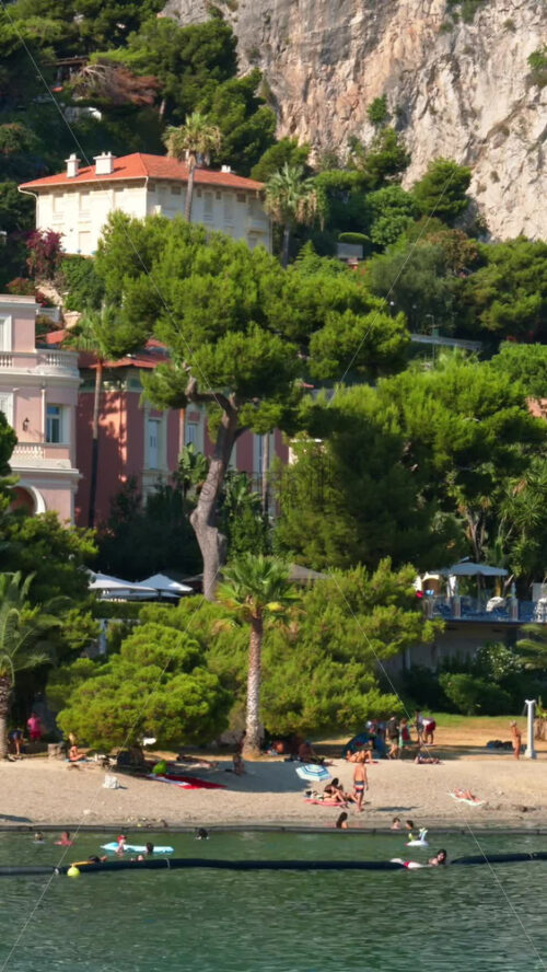 Video - Beaulieu-sur-Mer, France - July 5, 2024: People swimming and relaxing at the Petite Afrique Beach. Vertical