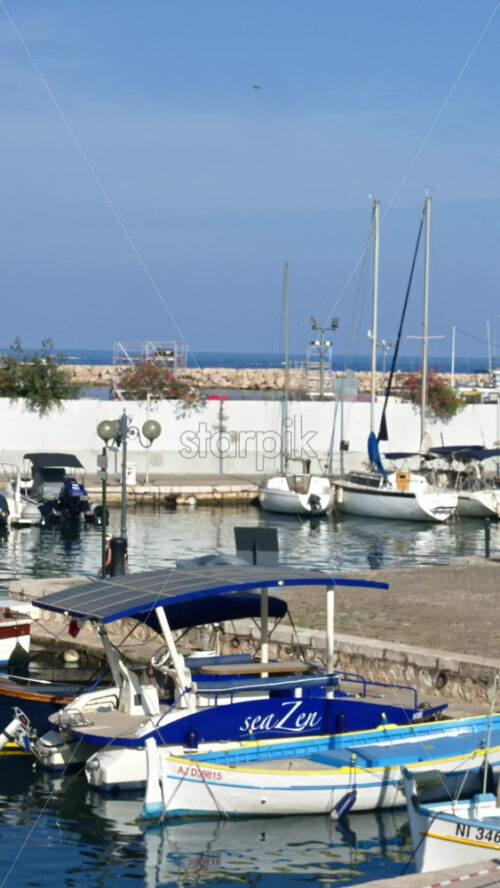 Video - Beaulieu-sur-Mer, France - June 28, 2024: View of white boats docked in the Beaulieu-sur-Mer harbour. Vertical