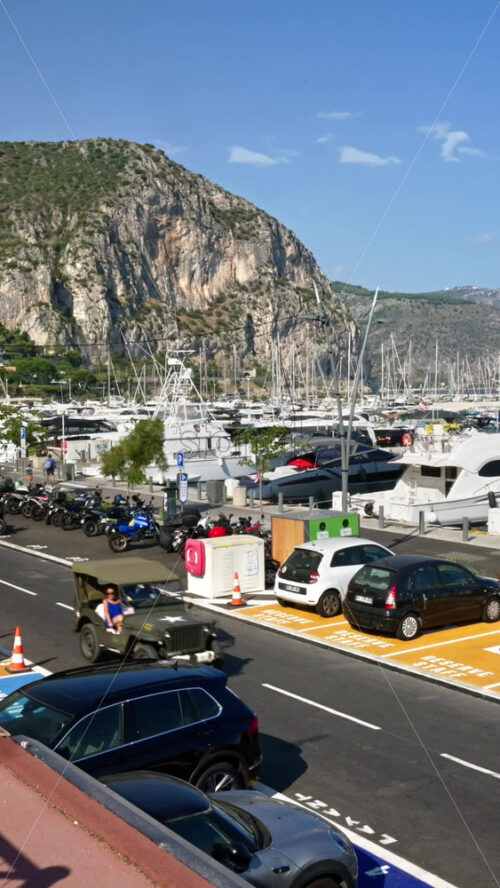 Video - Beaulieu-sur-Mer, France - July 5, 2024: Cars moving on the streets of the city near the port. Vertical