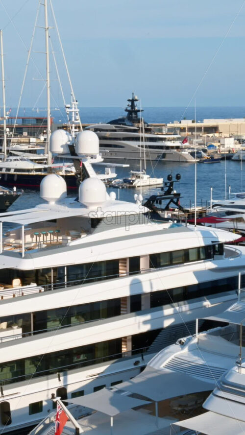 Video - View of white boats docked in the Monaco Marina with the skyline of the city on the background. Vertical