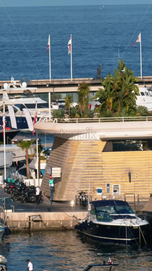 Video - La Condamine, Monaco - September 8, 2024: View of boats docked in the Monaco Marina with people moving near it. Vertical