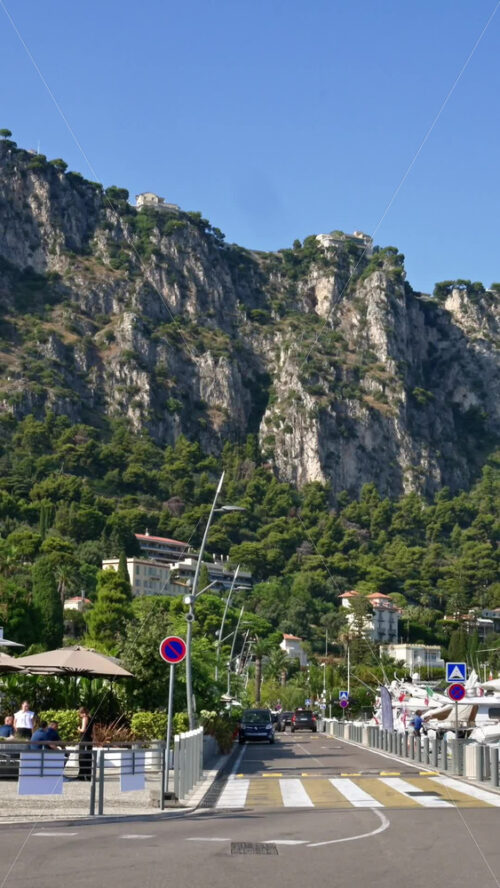 Video - Beaulieu-sur-Mer, France - July 5, 2024: Cars moving on the streets of the city near the port. Vertical