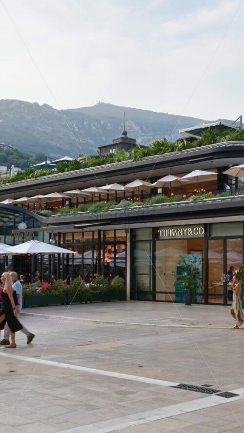 Video - Monaco City, Monaco - October 4, 2024: Luxury cars parked and people moving in front of a Tiffany and Co. store in the city. Vertical