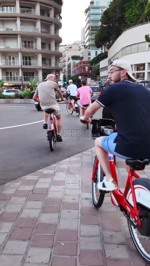 Video - Monaco city, Monaco - September 14, 2024: People biking on the streets of the city in daylight. Vertical