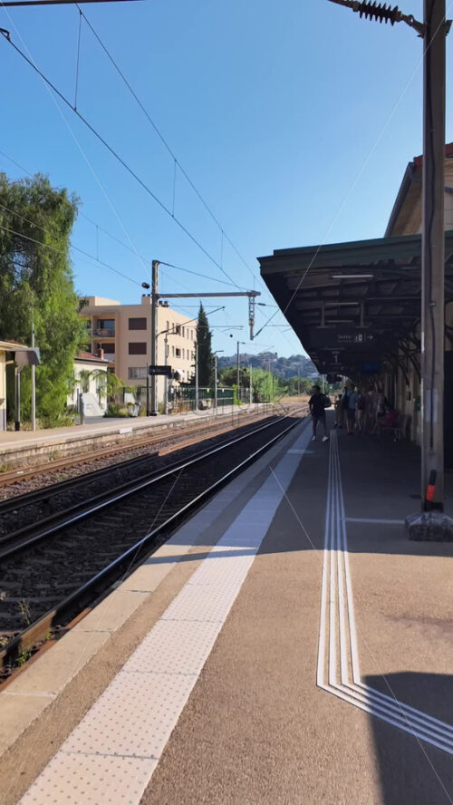 Video - Beaulieu-sur-Mer, France - July 5, 2024: People waiting for the trains at the Gare de Beaulieu-sur-Mer in daylight. Vertical