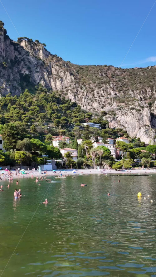 Video - Beaulieu-sur-Mer, France - July 5, 2024: People swimming and relaxing at the Petite Afrique Beach. Vertical