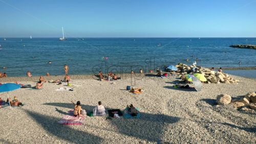 Video - Menton, France - September 4, 2024: People swimming and relaxing on the beach