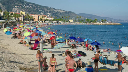 Video - Menton, France - September 4, 2024: People swimming and relaxing on the beach