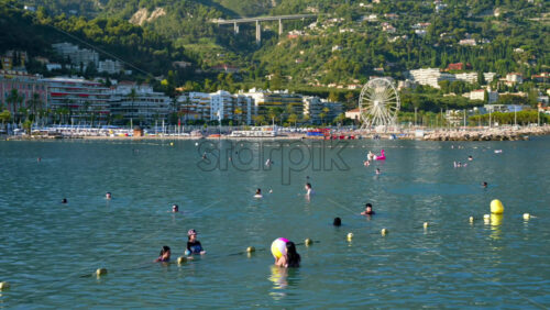 Video - Menton, France - September 4, 2024: People swimming and relaxing on the beach