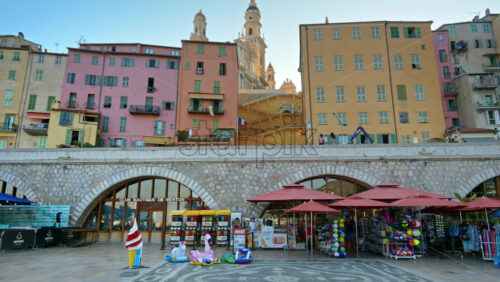 Video - Menton, France - September 4, 2024: View of the colourful buildings in the city and people walking by the coastline