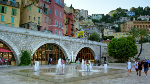 Video - Menton, France - September 4, 2024: View of the colourful buildings in the city and people walking by the coastline