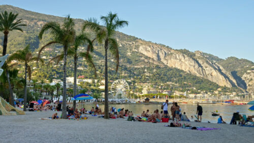Video - Menton, France - September 4, 2024: People relaxing on the beach near an urban sculpture
