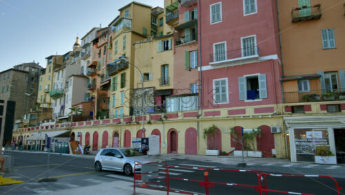 Video - Menton, France - September 4, 2024: View of the colourful buildings in the city and people walking by the coastline