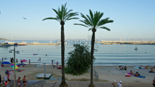Video - Menton, France - September 4, 2024: People walking and relaxing on the beach in the evening