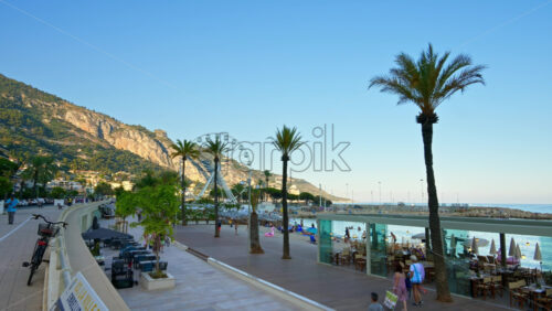 Video - Menton, France - September 4, 2024: Distant view of a white Ferris Wheel on the beach